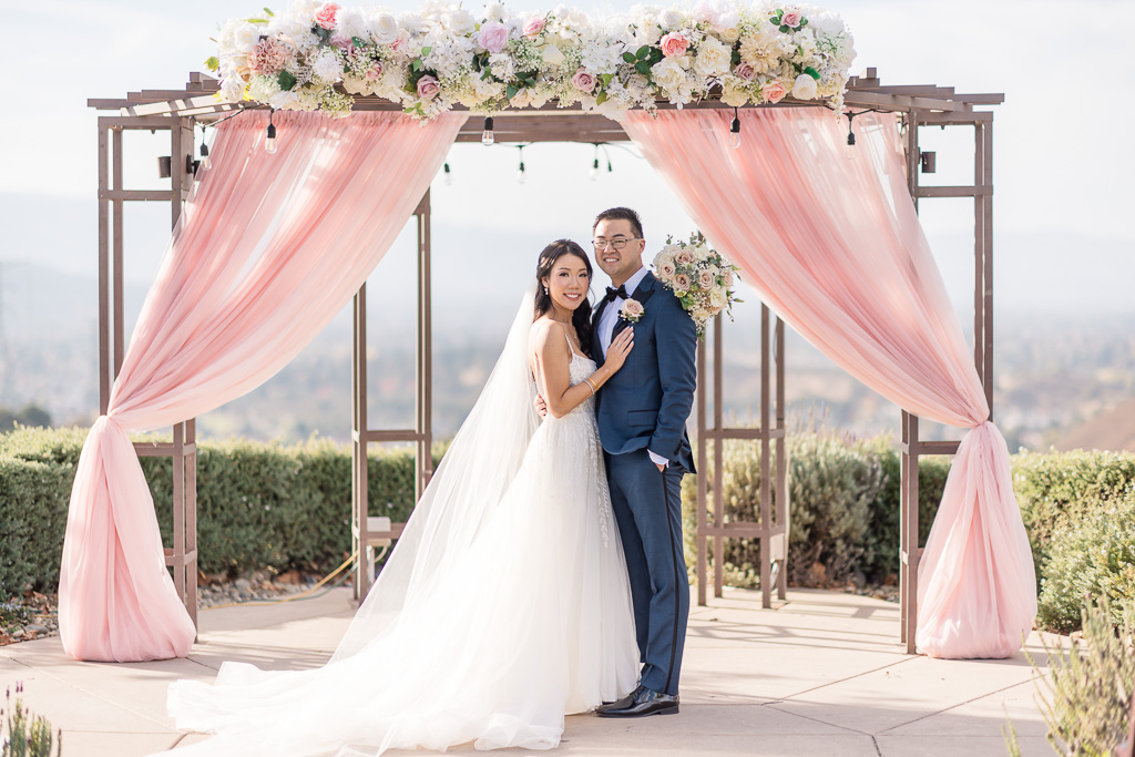 formal photo of bride and groom looking at the camera