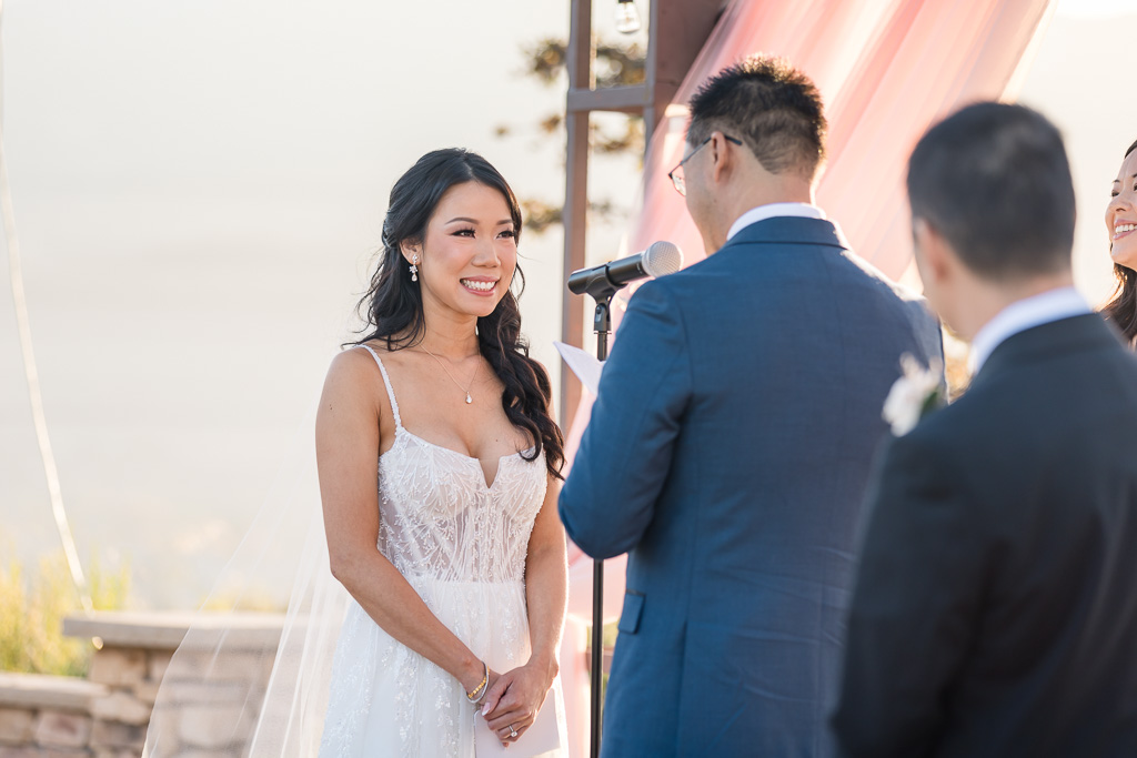 bride smiling at the groom during wedding ceremony