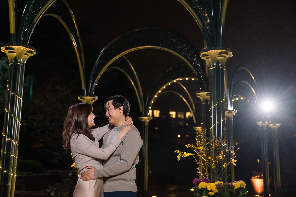 engagement photos at night with string lights in the background