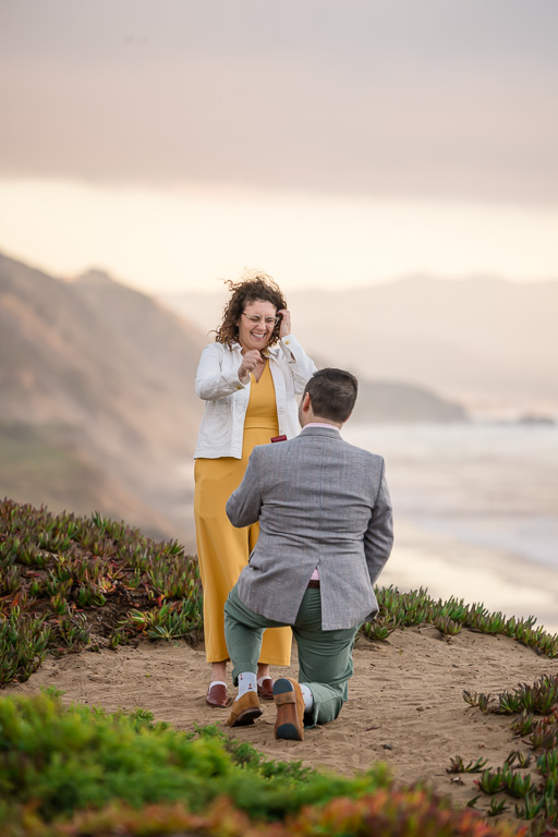 surprise proposal on a high ocean bluff at sunset