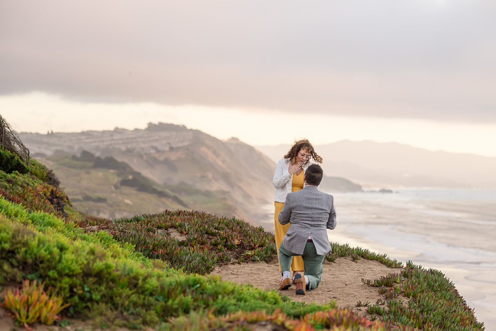 mountainside surprise proposal overlooking the ocean at sunset