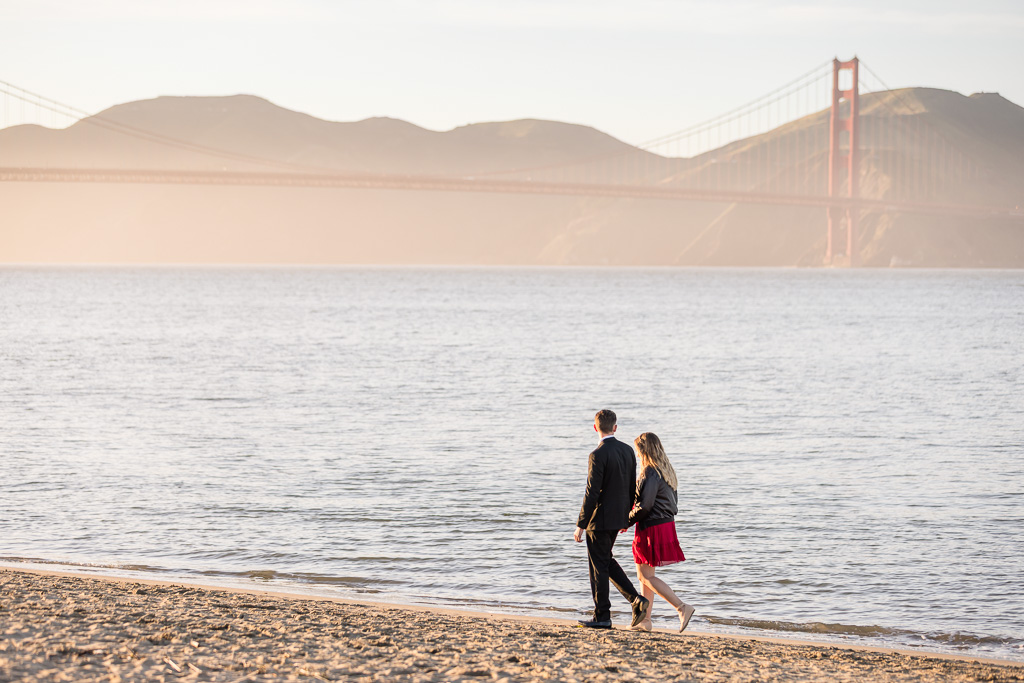 couple walking along the sands of a Presidio Beach at golden hour