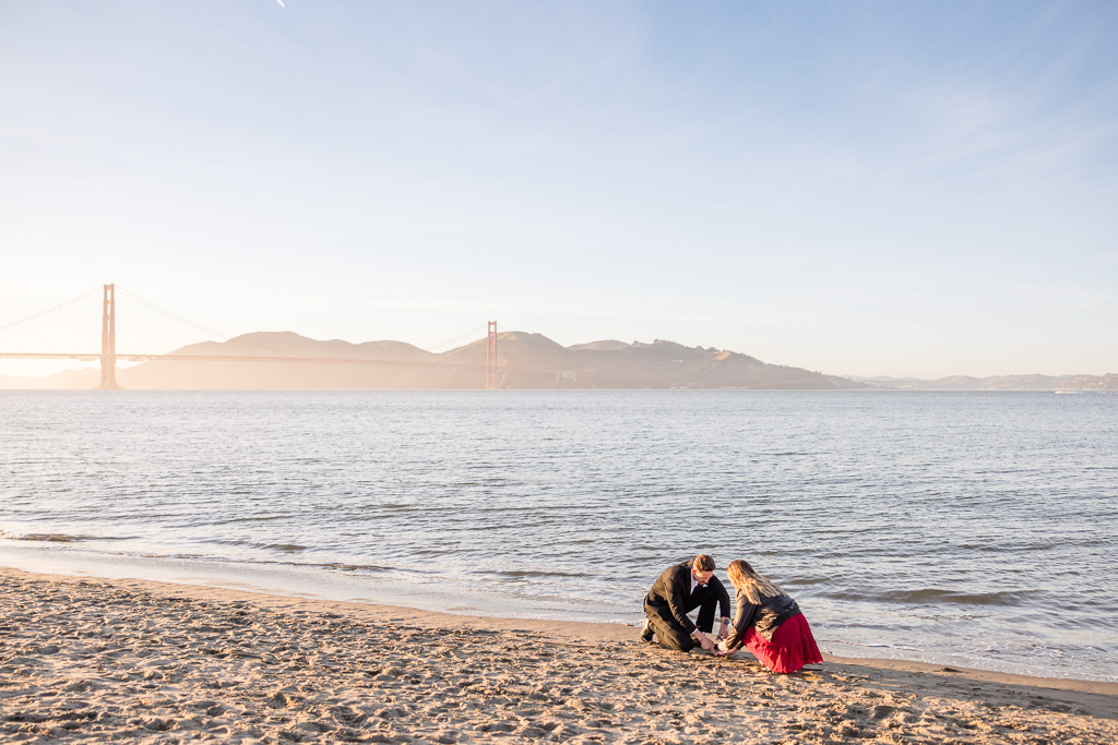 scooping up a small vial of sand to mark their proposal spot