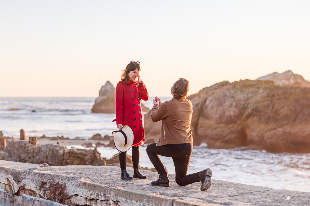 emotional reaction to surprise proposal near the ocean at sunset