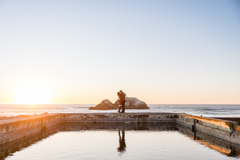 artistic capture of a surprise engagement at sunset along the ocean