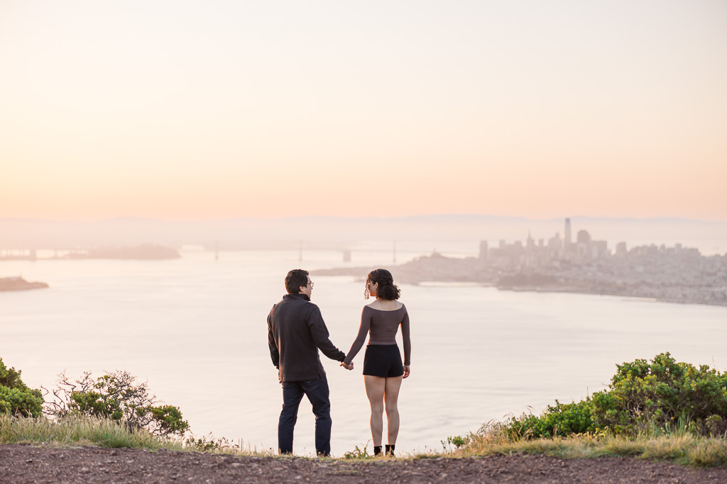couple facing the San Francisco Bay looking at the sunrise