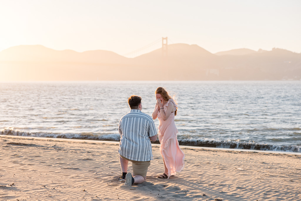 beautiful emotional surprise proposal at golden hour on the beach in San Francisco