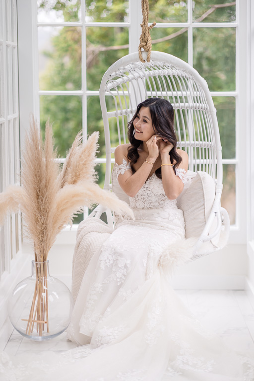 bride relaxing on a white hanging wicker chair