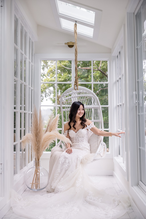 bride solo portrait on a white hanging chair before the wedding