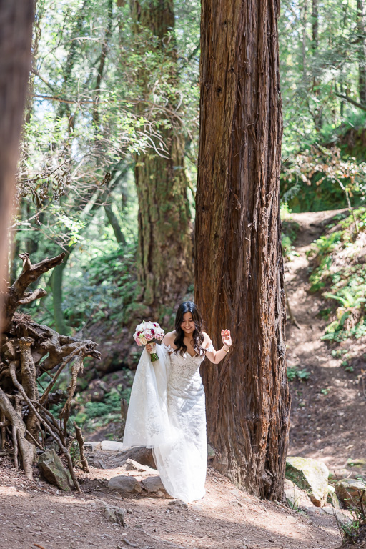 bride walking past redwood trees to her first look
