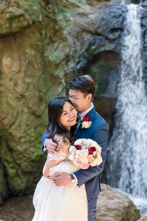 bride and groom at waterfall