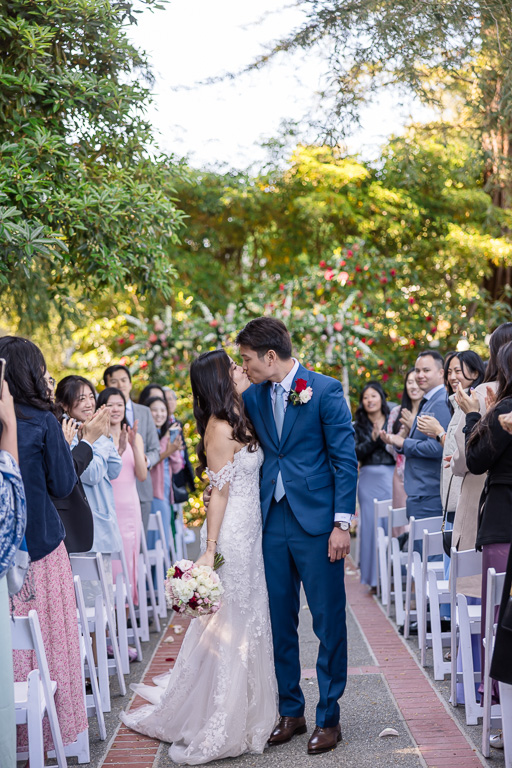 a kiss at the end of the ceremony aisle