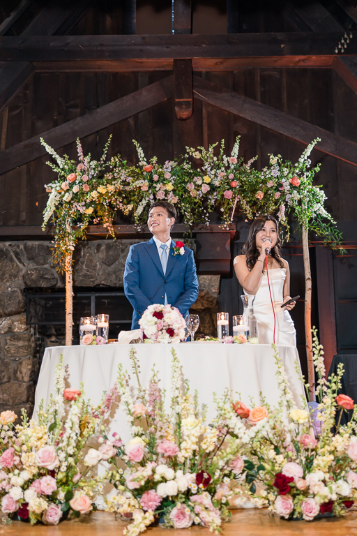 bride and groom at sweetheart table giving welcome speech