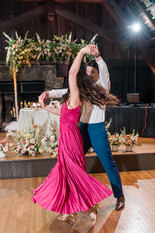 groom giving the bride a twirl during indoor first dance