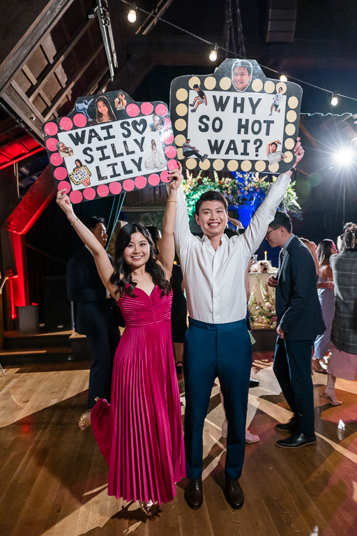 bride and groom holding up some punny signs during reception