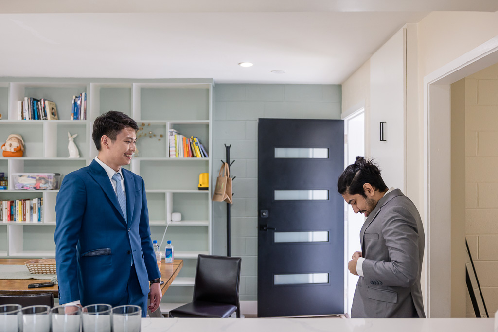 candid moment of groom and groomsman getting ready