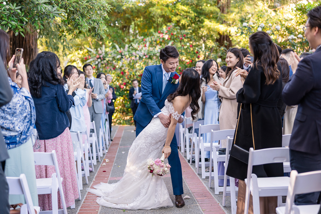 dip and kiss at the end of the ceremony aisle during recessional
