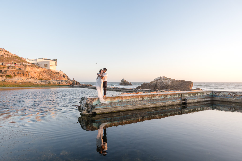 gorgeous sunset engagement photos at Sutro Baths with colorful reflection