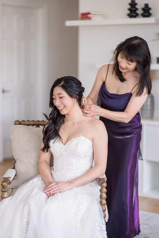 moment with mom helping bride with her earrings