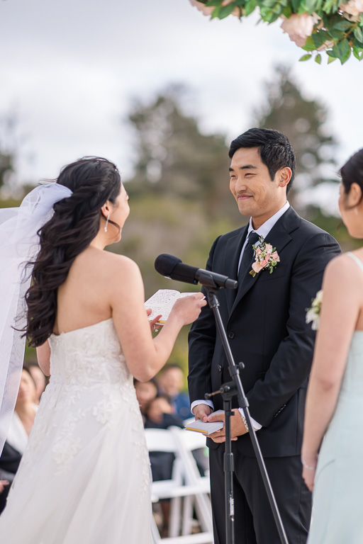 bride delivering her personal written vows to the groom during beach wedding ceremony