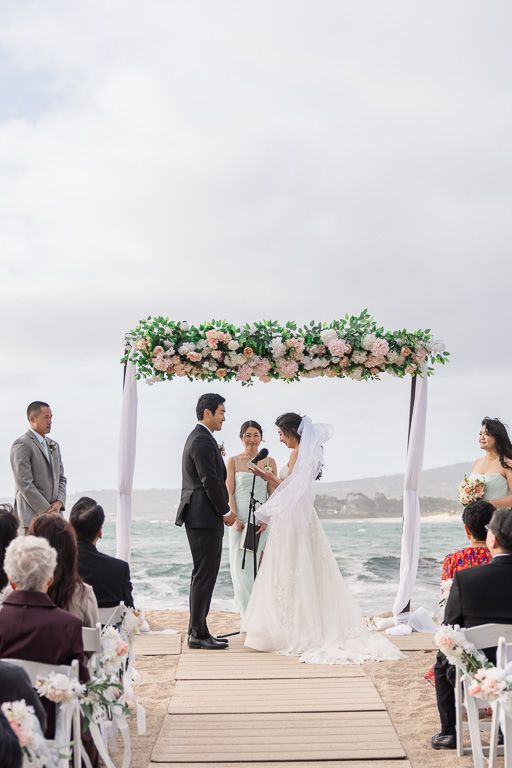 beach ceremony with floral arbor