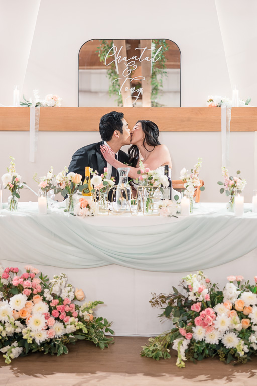bride & groom kissing at the sweetheart table