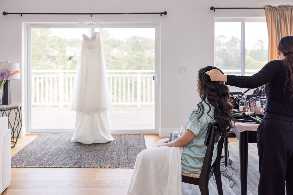 wedding getting ready photo at an Airbnb with wedding dress hanging on glass door