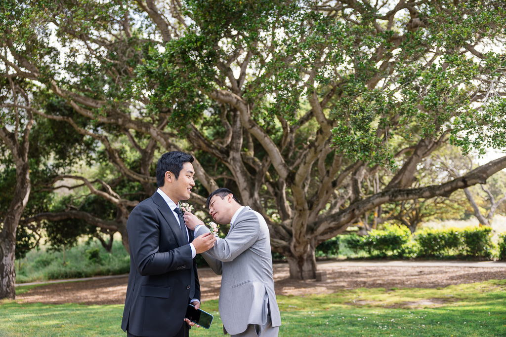 pinning the boutonniere on the groom