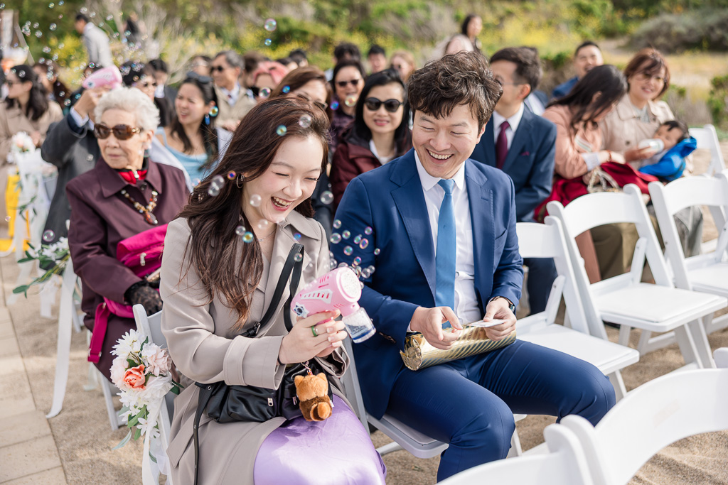 wedding guests playing with a bubble blowing machine