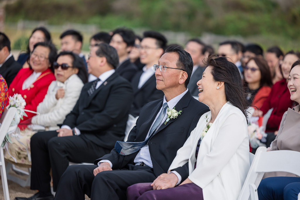 parents seated in the front row of wedding ceremony chairs