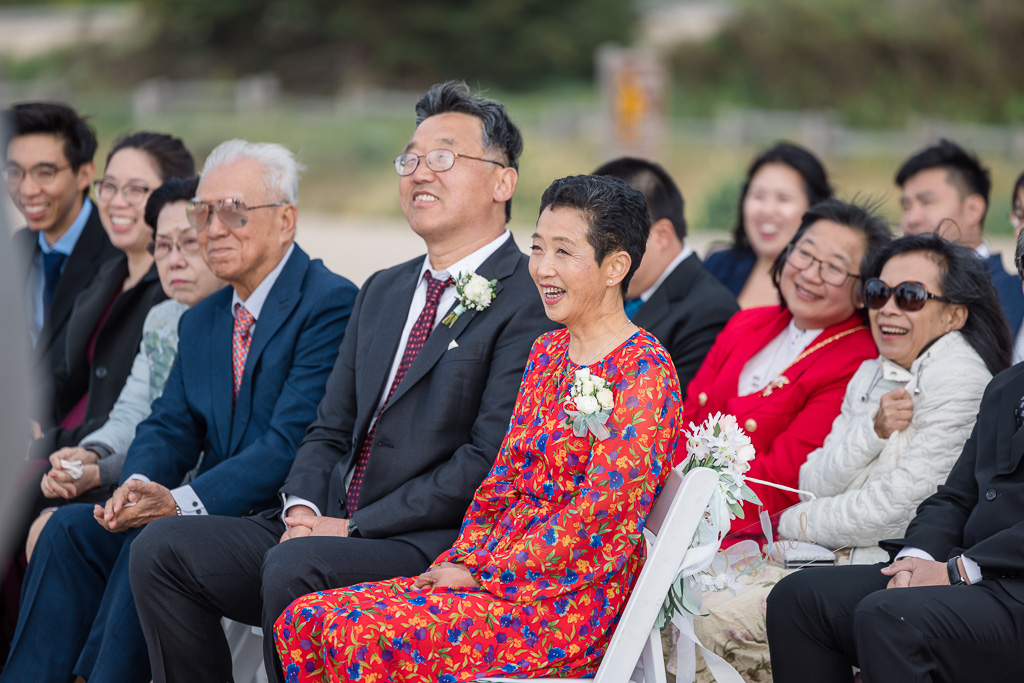 parents joyfully seated at wedding ceremony on the beach