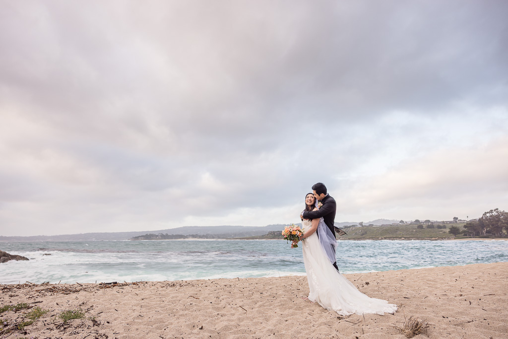 bride & groom wedding portrait under stormy skies at the ocean
