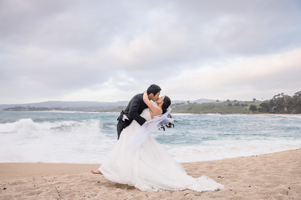 romantic wedding photo on Monastery Beach with layered clouds in the background