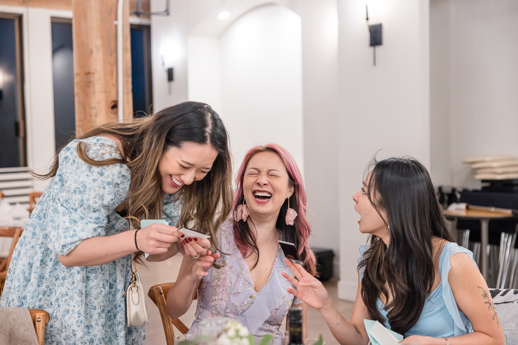 wedding guests laughing while reading personalized notes left by the couple