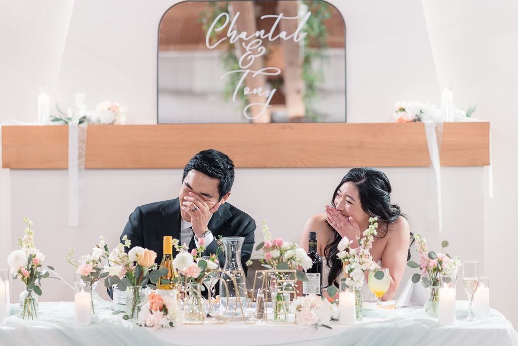 bride and groom laughing at dinner toasts