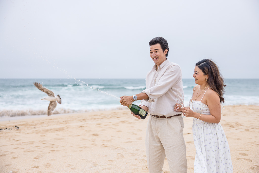 opening champagne on a beach