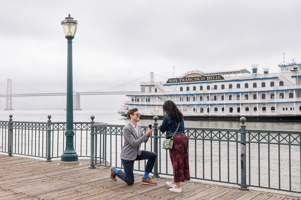 Pier 7 surprise proposal with the San Francisco Belle boat and Bay Bridge in the background