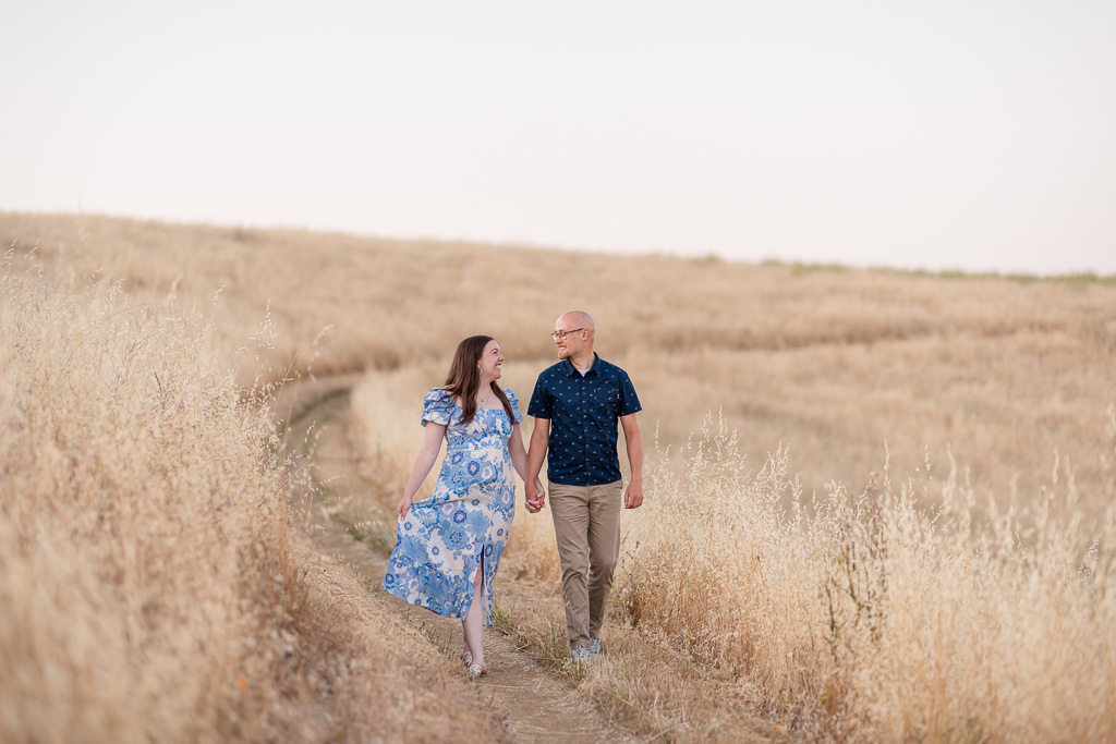 engagement photos at golden grassy field at dusk