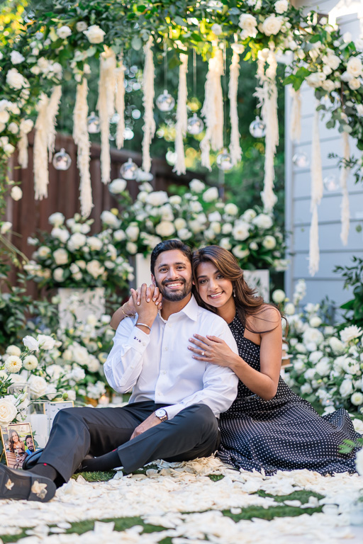 engagement photos in backyard with white flower petals