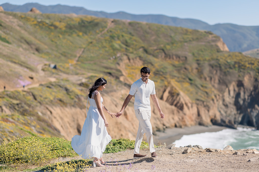 couple walking along the cliff edge at Mori Point