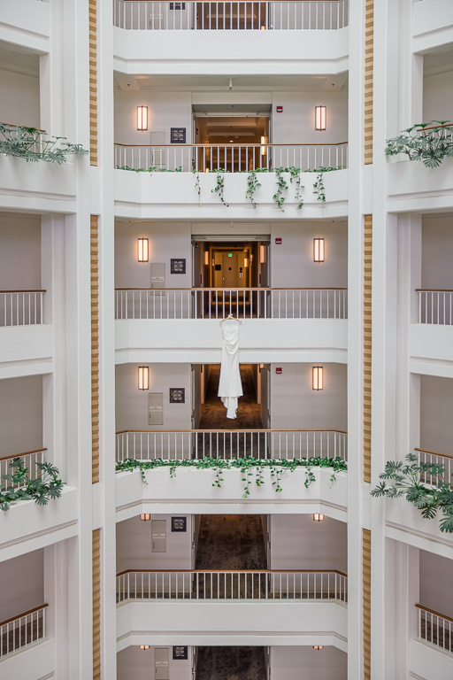 wedding dress hanging in atrium of hotel