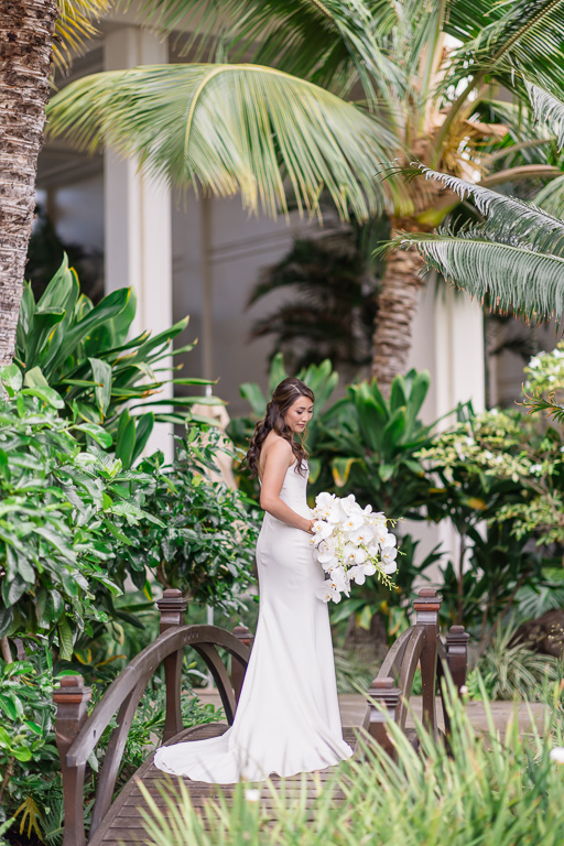 bride solo on a small wooden bridge in a lush tropical setting
