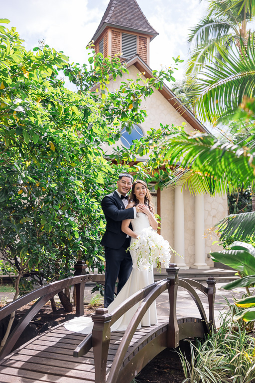 portrait of the newlyweds in front of little chapel at the Four Seasons Ko Olina