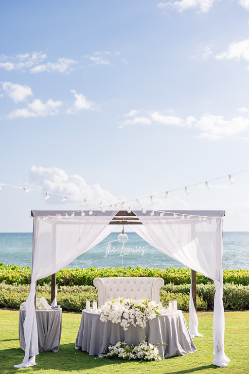 sweetheart table with draped linens and custom neon sign
