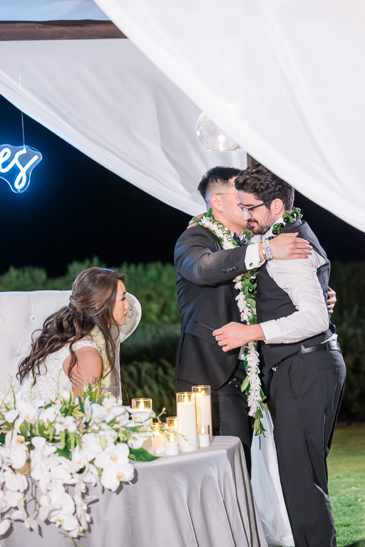 groom giving his groomsman a hug after dinner toast