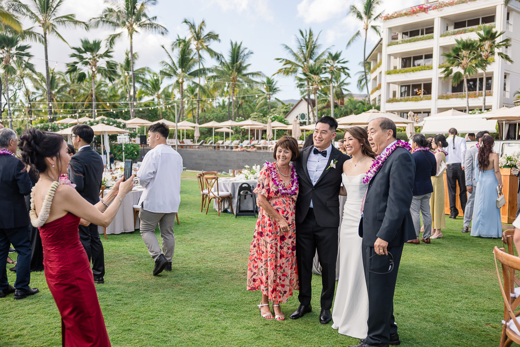 mom taking a photo of the couple with some guests