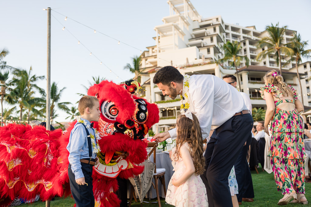 guests and kids presenting red pockets to the lion dancers
