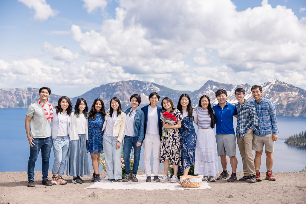 big group photo of newly engaged couple and all their friends who were in on the plan