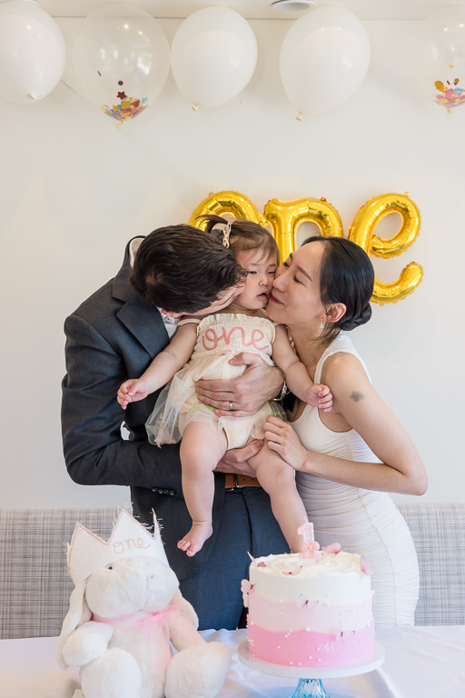 parents smothering baby daughter with kisses