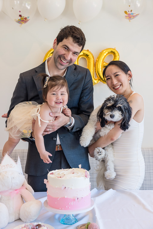 family photo with baby, dog, and birthday cake